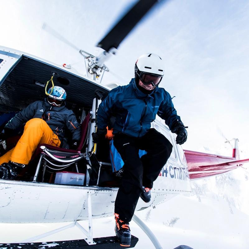 A skier getting out of a helicopter.