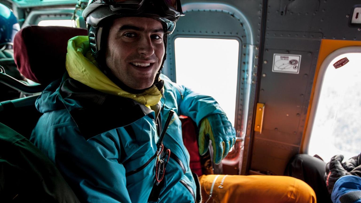 A skier seated in a helicopter